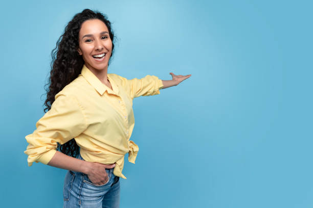 istock Special offer, advertisement concept. Joyful millennial woman pointing at empty space on blue studio background 1475624388