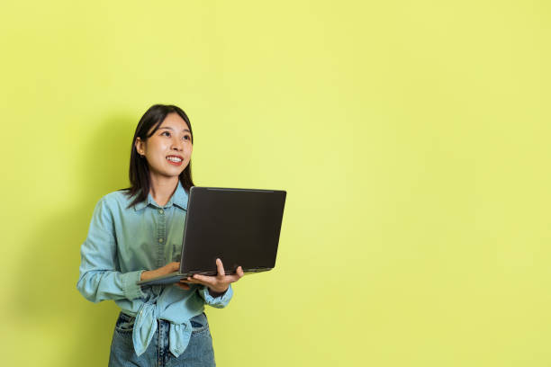 istock Japanese Woman Using Laptop Browsing Internet Over Yellow Background 1475624450