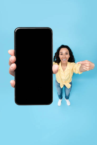 istock Happy lady showing blank mobile phone screen at studio 1475624526