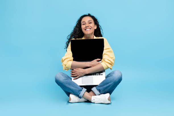 istock Middle Eastern Woman Hugging Laptop Computer Sitting On Blue Background 1475624550