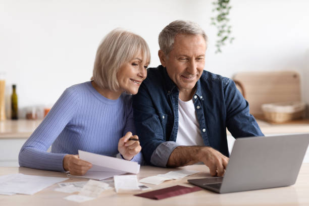 istock Happy senior couple paying bills online, using computer 1475624590
