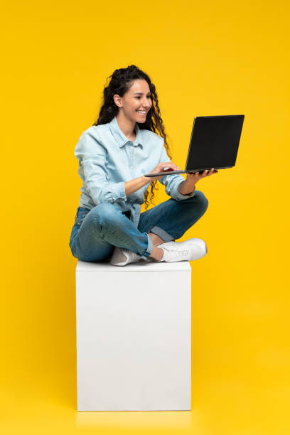 istock Arabic Lady Using Laptop Sitting Over Yellow Background, Vertical 1475624763