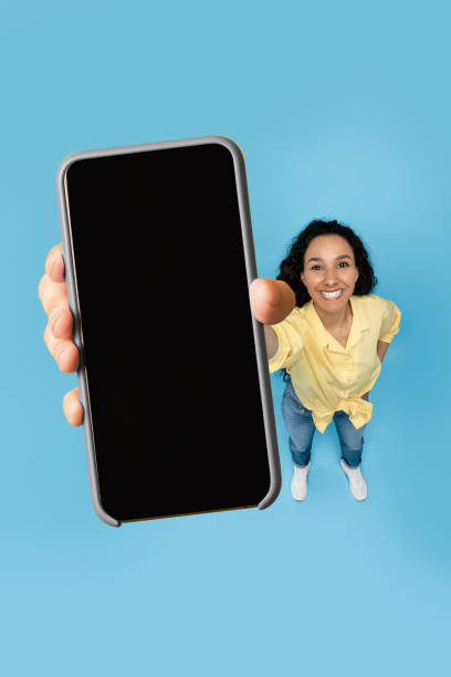 istock Happy lady showing blank mobile phone screen at studio 1475624877