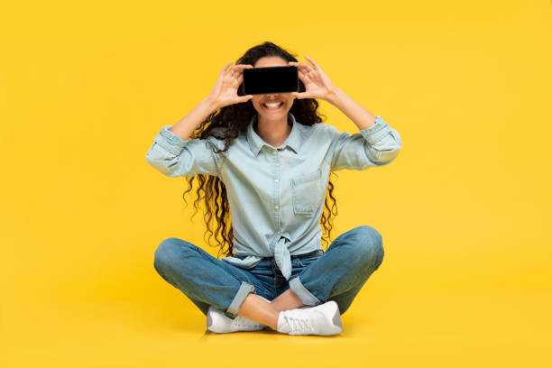 istock Excited woman covering eyes with empty smartphone screen 1475624881