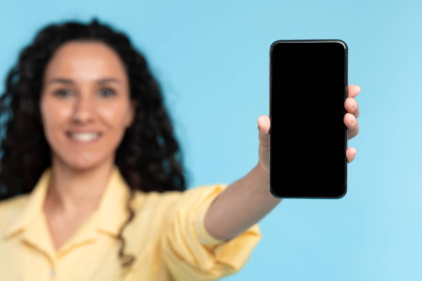 istock Closeup of lady holding showing black empty smart phone screen 1475624882