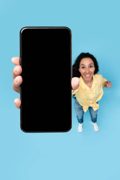 istock Happy woman showing blank mobile phone screen at studio 1475624883