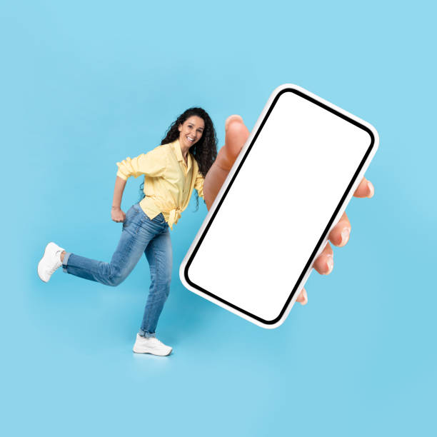 istock Cheerful Middle Eastern Lady Showing Huge Smartphone Over Blue Background 1475624901