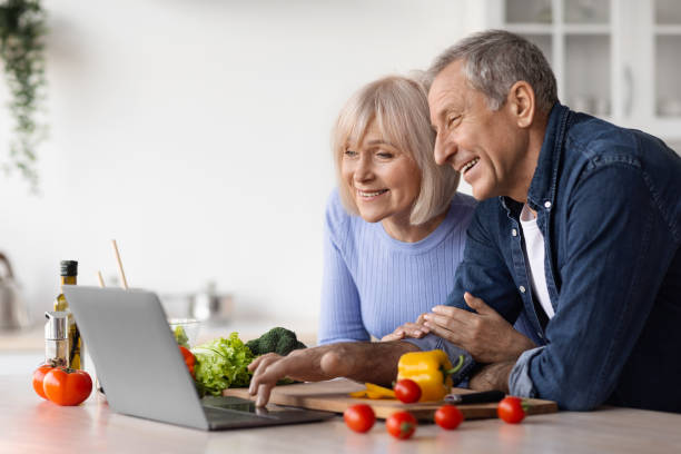 istock Cheerful senior couple watching food vlog while cooking, copy space 1475624968