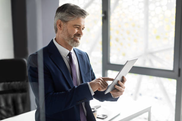 istock Successful Mature Businessman Using Digital Tablet At Workplace In Office 1475624982