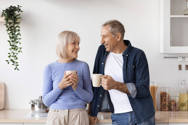 istock Couple of pensioners drinking coffee at kitchen 1475625113