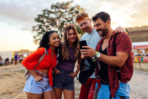 istock Cheerful friends using phone at festival 1475631704