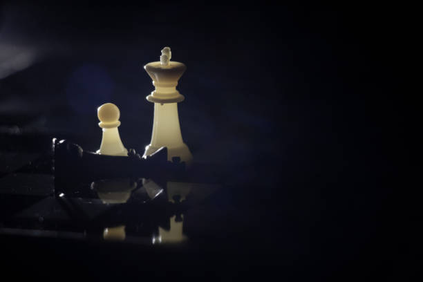 istock chess pieces on a chessboard in a dark room illuminated by a lamp 1475631779