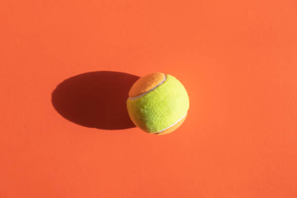 bola de tênis de praia no fundo da cor laranja. cartaz desportivo horizontal, cartões de felicitações, cabeçalhos, website - tennis court sport net - fotografias e filmes do acervo