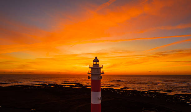 stunningly beautiful sunset behind the historic faro del toston traditional lighthouse near el cotillo and corralejo in fuerteventura canary islands spain - el cotillo imagens e fotografias de stock