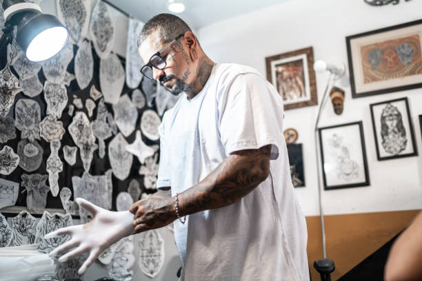 istock Tattoo artist putting gloves on at a tattoo studio 1475635569