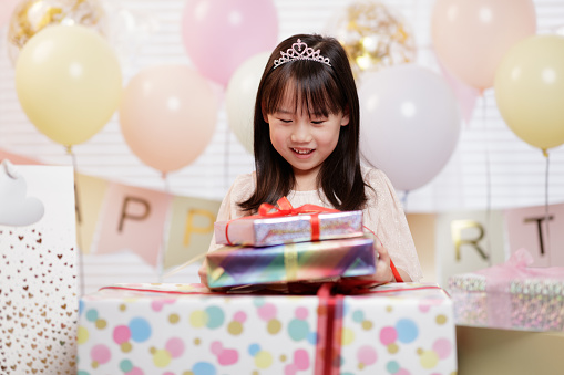 medium shot young girl unpacking gift box celebrating her 7th birthday at home