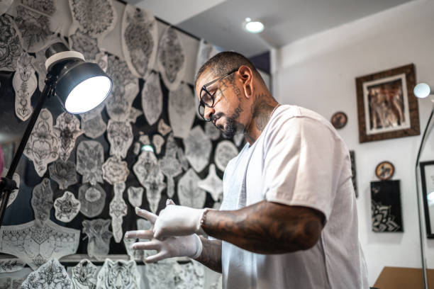 istock Tattoo artist putting gloves on at a tattoo studio 1475635780