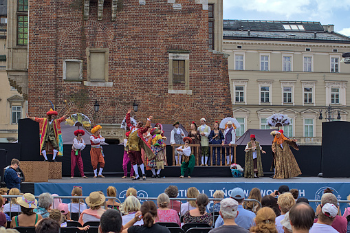 Krakow, Poland - July 24, 2022: Theatrical performance on the main square. Street Theater Festival. The performers perform in great costumes. Entrance to the performance is free.
