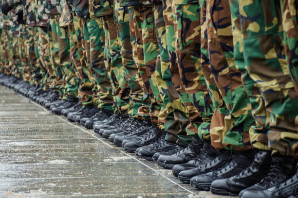 militärstiefel und tarnhosen vieler soldaten - militärisches trainingslager stock-fotos und bilder