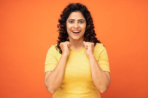 Portrait of amazing girl perfect ideal best win raised hand eyes closed in orange background