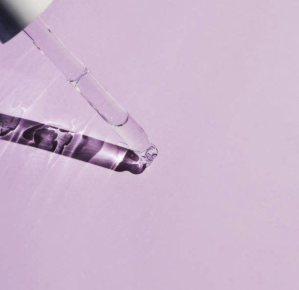 istock A glass pipette with a cosmetic product inside on a pale pink background. Side view, space for text. 1475641071