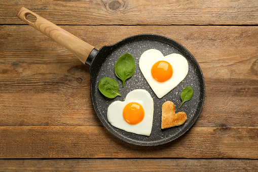 Heart shaped boiled eggs on wood table