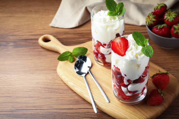 istock Delicious strawberries with whipped cream served on wooden table. Space for text 1475641179