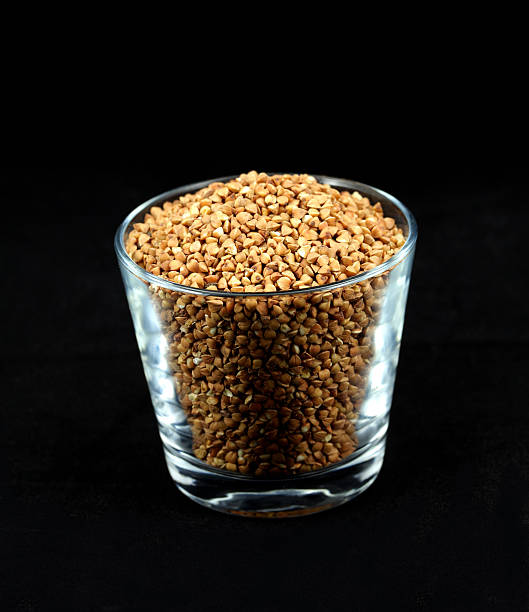 Buckwheat millet kernels in a cup on black stock photo