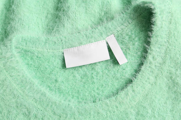 Blank clothing label on light green sweater, top view