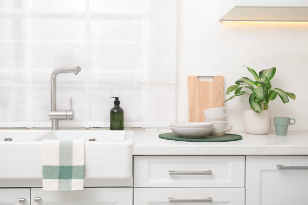istock Kitchen counter with sink, houseplant and clean dishes 1475644870