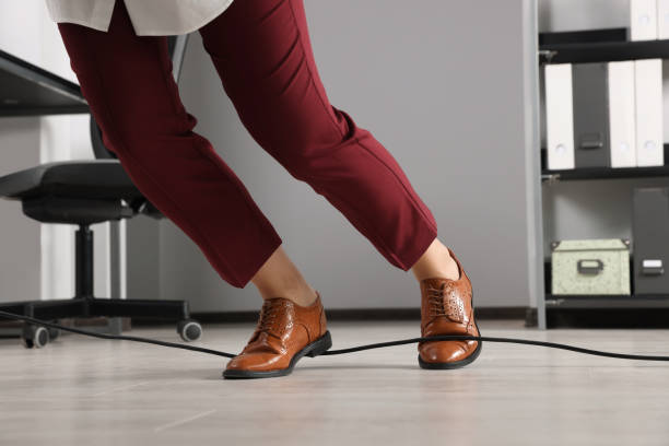 istock Woman tripping over cable in office, closeup 1475644935