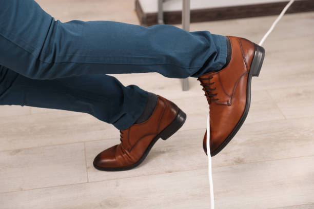 istock Man tripping over cord in office, closeup 1475644972
