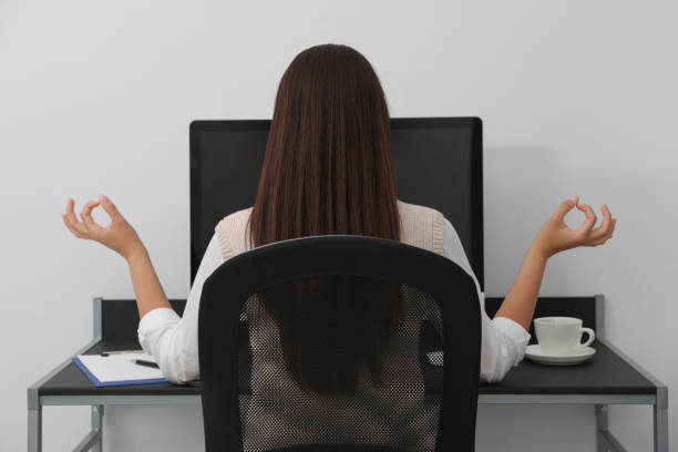 istock Businesswoman meditating at workplace, back view. Zen concept 1475645202