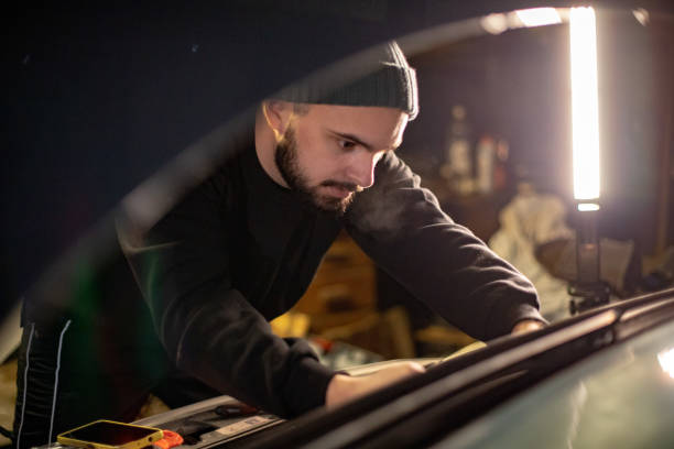 istock Young man servicing his car on his own at home in his garage. 1475646161