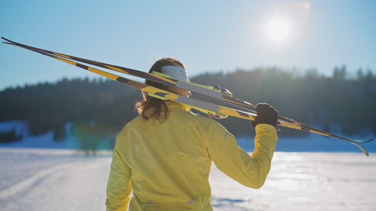 SLO MO Cross-Country skier carries her skis on the shoulder. Lets begin to train.