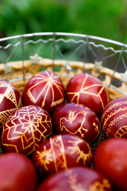 istock Closeup of basket of colored red eggs, Easter holiday concept. Modern painted easter eggs. Collection of pysanka or krashanka. Vertical. Out of focus 1475651423