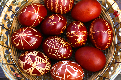 Easter eggs top view. Closeup of basket of colored red eggs, Easter holiday concept. Collection of pysanka or krashanka. Close up. Out of focus.