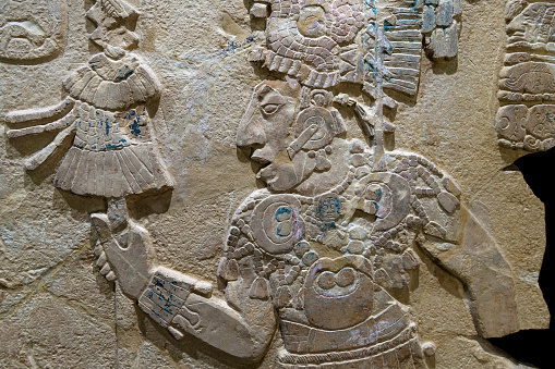 Maya bas relief carving in a stele tombstone of a mayan ruler king with staff of power, Palenque, Mexico.