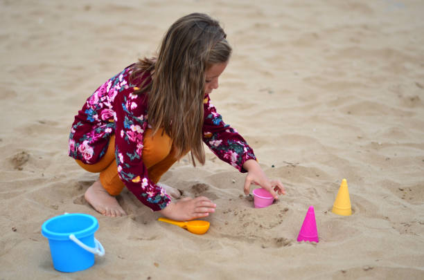 istock A child plays with sand on the beach 1475655212