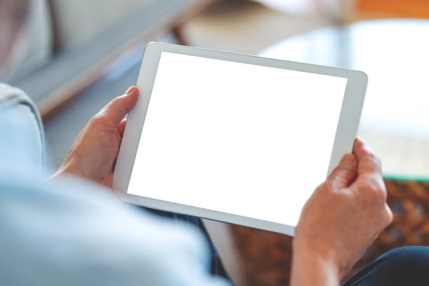Mature man using a blank screen digital tablet at home. stock photo