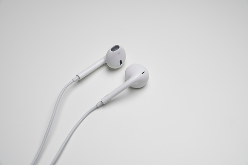 iPhone Apple Earpods, Airpods white earphones, headphones for listening to music and podcasts. Isolated white background. Budapest, Hungary - February 16, 2023