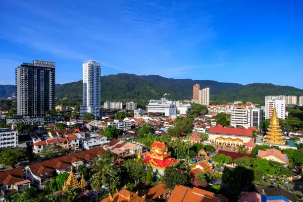 Modern city skyline cityscape of and the Thai temple Wat Chayamangkalaram a Thai temple in Pulau Tikus suburb of George Town, Penang, Malaysia.