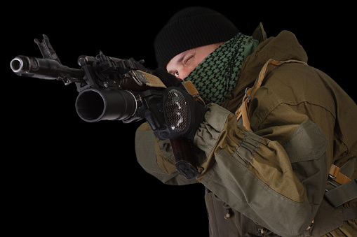 pro-Russian militiaman with kalashnikov ak-47 rifle with under-barrel grenade launcher on black background