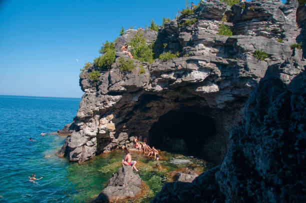 la cueva de la gruta en la península de bruce con turistas en las rocas de georgian bay - natural landmark nature recreational pursuit ontario fotografías e imágenes de stock