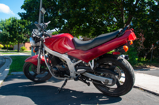 Oakville, Ontario - July 8, 2017: A red motorcycle parked on the road during a sunny day in the summer
