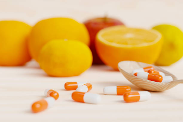 istock A nutritional supplement on a spoon with oranges, apples, lemons, and other fruits behind it. 3d rendering 1475672318