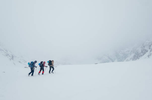 istock Three members rope team ascending the high mountain winter peak. Blizard covering the structural basin in Vysoke Tatry (High Tatras) mountains under Lomnicky Stit roky mountain. Extreme sport concept. 1475676007