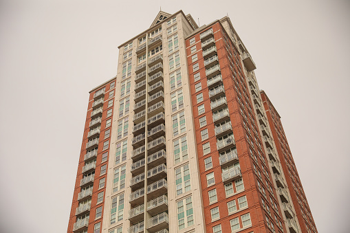 skyscraper's towering structure and old-fashioned architecture. multiple stories, with numerous rows of brickwork stacked upon each other to form its exterior walls. The bricks are weathered and worn