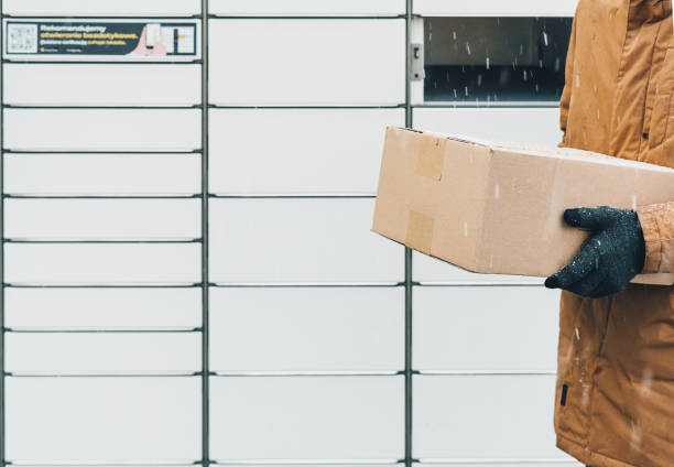 istock A man with a box in his hands near the self-service mail terminal. Parcel delivery machine. Person holding a cardboard box. Mail delivery and post service, online shopping, e commerce concept 1475682053
