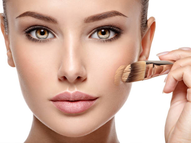istock woman applying liquid tonal foundation  on the face 1475686641